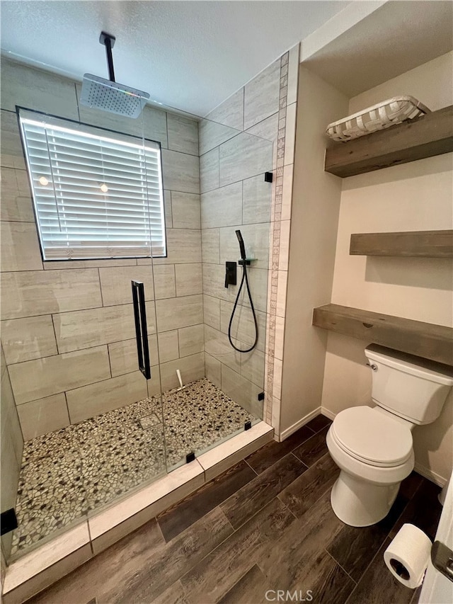 bathroom featuring walk in shower and toilet