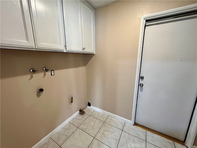 laundry area with cabinets, electric dryer hookup, and light tile patterned floors