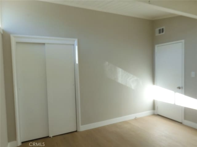 unfurnished bedroom with light wood-type flooring and a closet