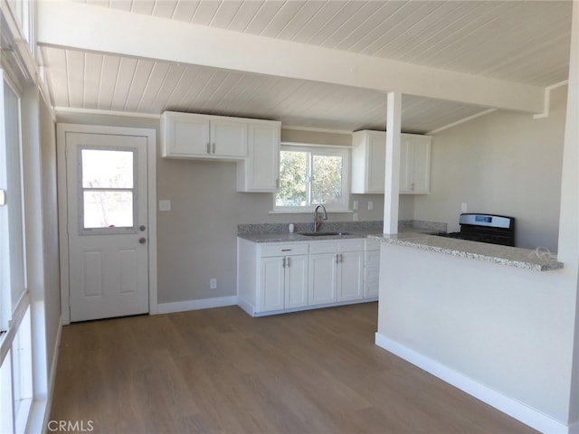 kitchen featuring hardwood / wood-style flooring, sink, beamed ceiling, and white cabinets