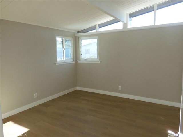 empty room featuring vaulted ceiling with beams and dark hardwood / wood-style flooring