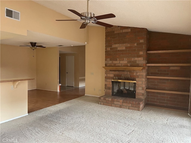 unfurnished living room with a brick fireplace, a textured ceiling, carpet floors, and ceiling fan