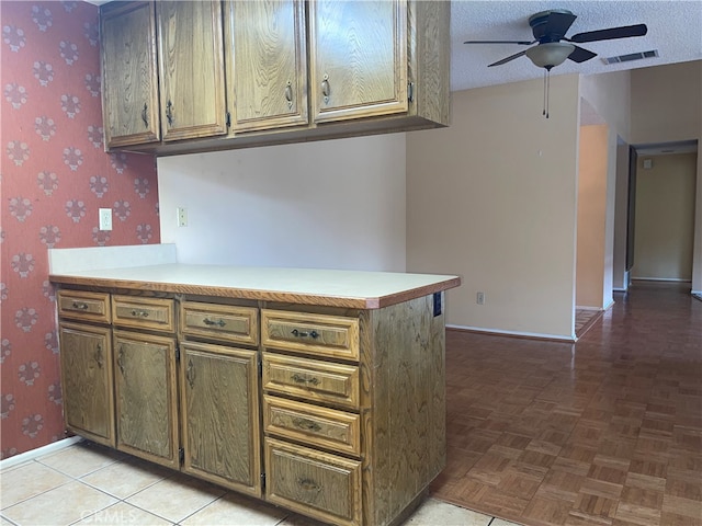 kitchen featuring kitchen peninsula, a textured ceiling, light parquet floors, and ceiling fan