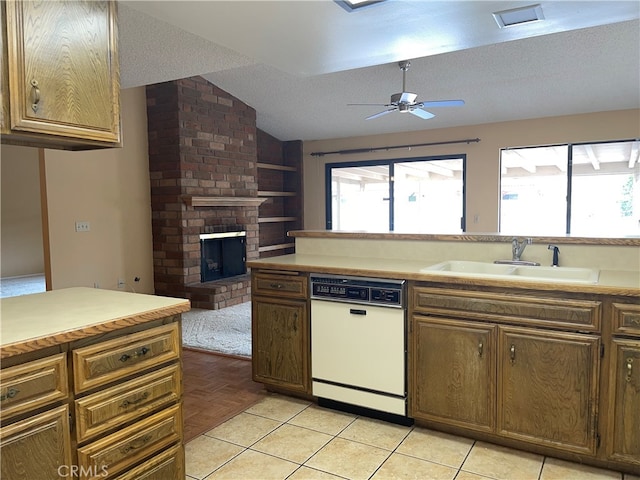 kitchen featuring dishwasher, a textured ceiling, vaulted ceiling, and sink