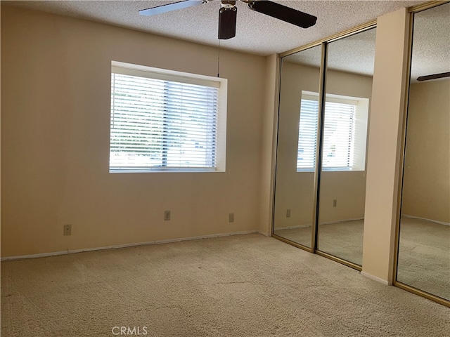 unfurnished bedroom with multiple windows, ceiling fan, and a textured ceiling