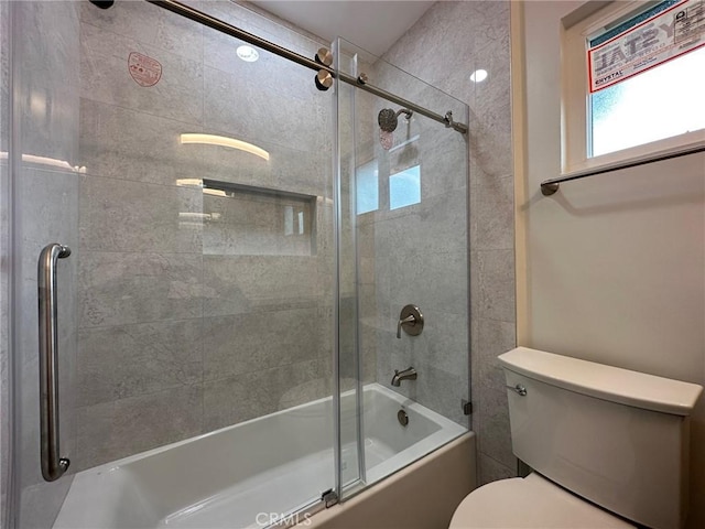 bathroom featuring shower / bath combination with glass door and toilet