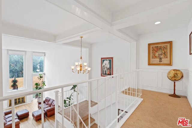 interior space with carpet flooring, beamed ceiling, and a chandelier