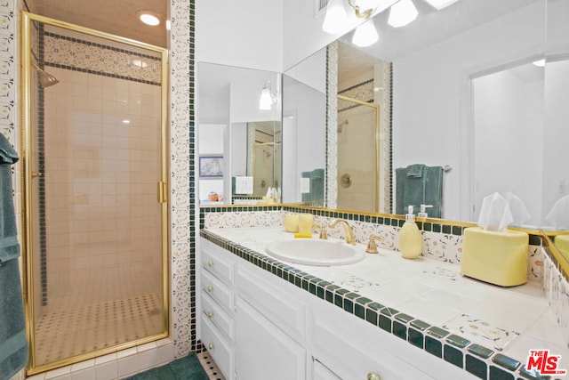 bathroom with tile patterned floors, vanity, and walk in shower