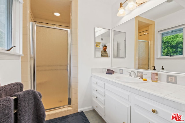 bathroom featuring tile patterned flooring, vanity, and a shower with shower door