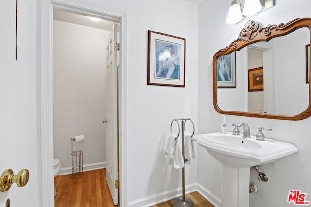 bathroom with toilet and wood-type flooring