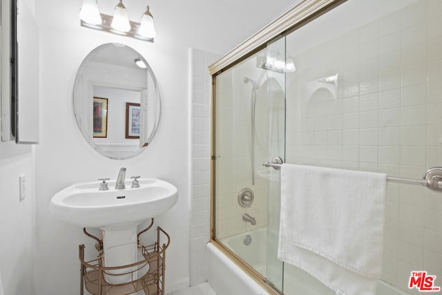 bathroom featuring bath / shower combo with glass door