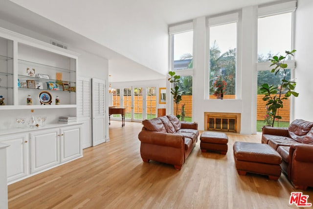 living room featuring light wood-type flooring and a high ceiling