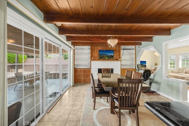 sunroom / solarium featuring a brick fireplace, beam ceiling, and wooden ceiling