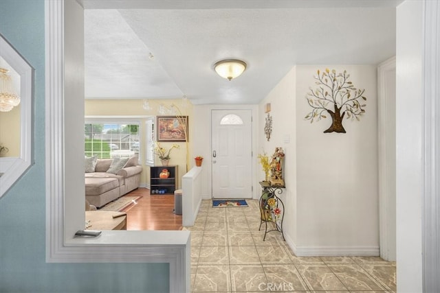 tiled foyer entrance featuring a textured ceiling