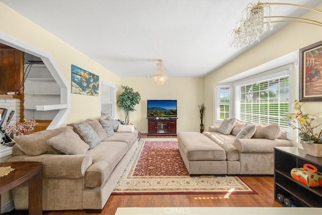 living room with an inviting chandelier, a fireplace, and hardwood / wood-style floors