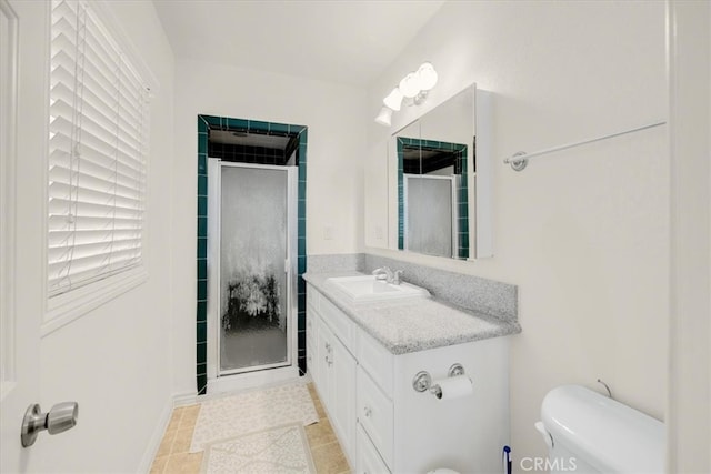 bathroom featuring tile patterned floors, a shower with door, vanity, and toilet