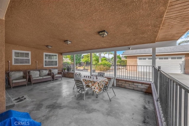 view of patio with outdoor lounge area and a garage