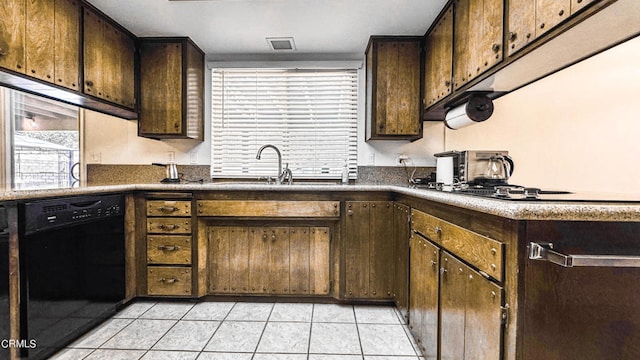 kitchen featuring dark brown cabinetry, dishwasher, sink, and light tile patterned flooring