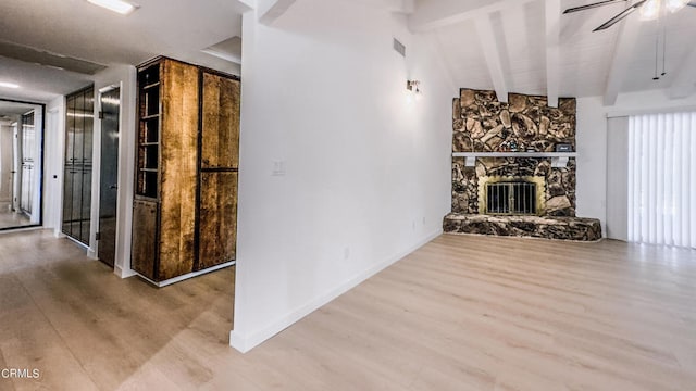 unfurnished living room with a fireplace, lofted ceiling with beams, hardwood / wood-style floors, and ceiling fan