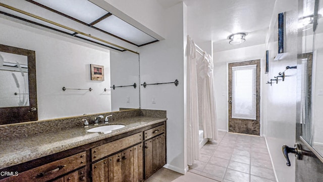 bathroom with tile patterned flooring, vanity, and curtained shower