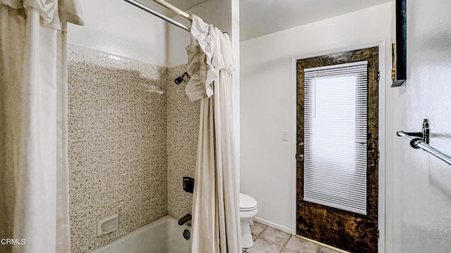 bathroom featuring shower / bath combo with shower curtain, tile patterned floors, and toilet