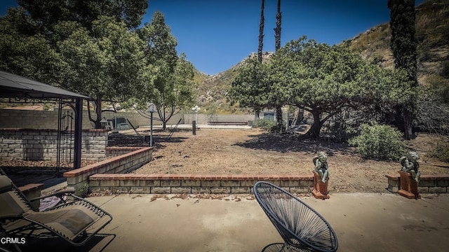 view of patio with a mountain view and a gazebo