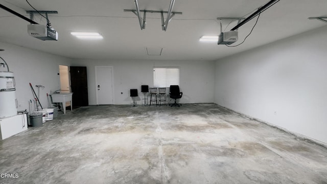 garage with strapped water heater, a garage door opener, and sink