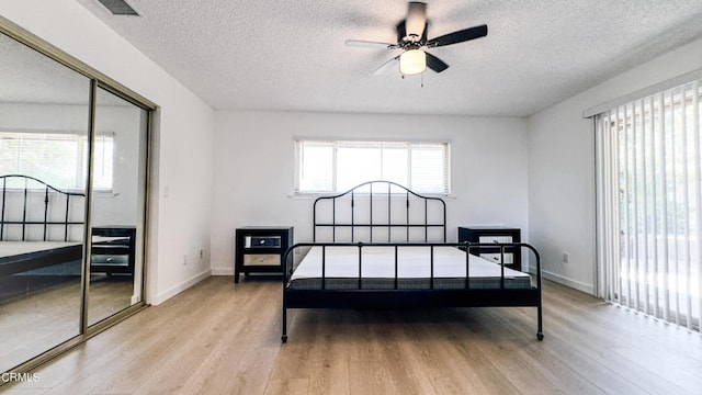 bedroom featuring a textured ceiling, a closet, and light wood-type flooring