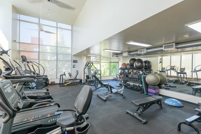 workout area with a wall of windows and ceiling fan