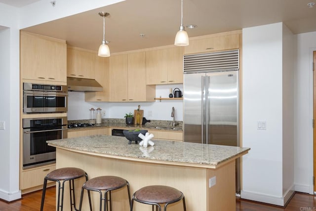 kitchen featuring pendant lighting, appliances with stainless steel finishes, dark hardwood / wood-style floors, and a kitchen island