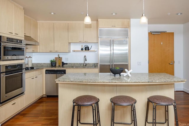 kitchen with a kitchen island, sink, dark wood-type flooring, and stainless steel appliances