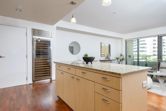 kitchen with pendant lighting, a center island, beverage cooler, dark hardwood / wood-style flooring, and light brown cabinetry