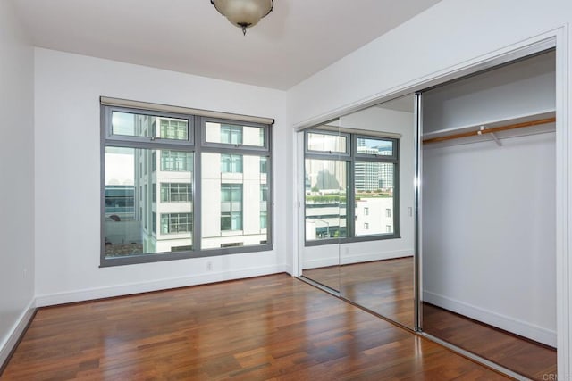 unfurnished bedroom featuring a closet and dark hardwood / wood-style floors