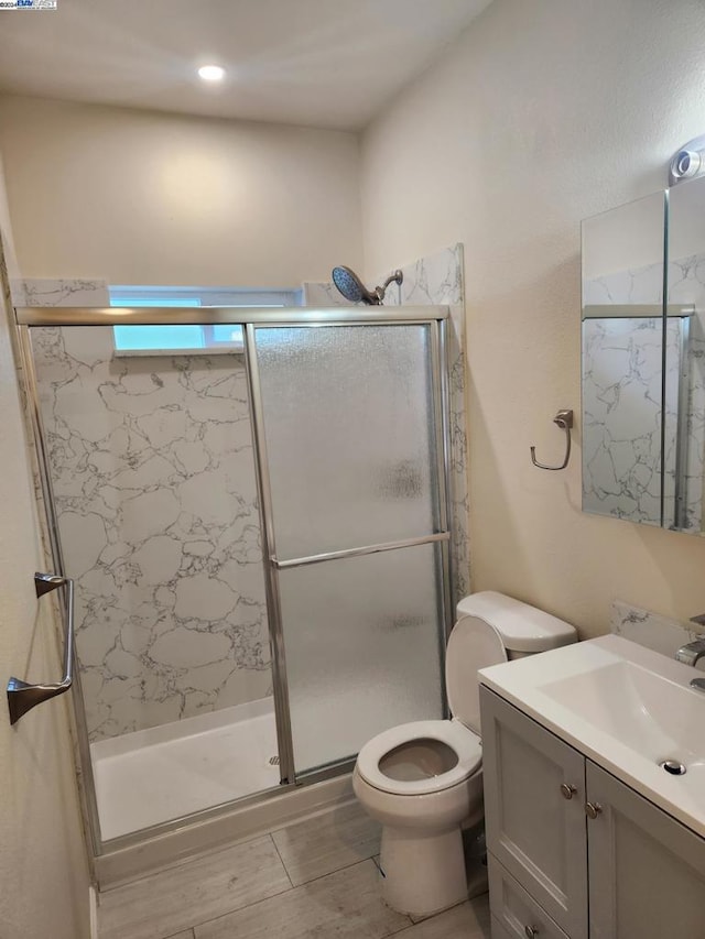 bathroom featuring hardwood / wood-style flooring, vanity, toilet, and an enclosed shower