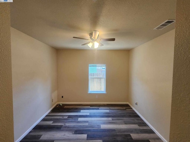 spare room with ceiling fan, dark wood-type flooring, and a textured ceiling