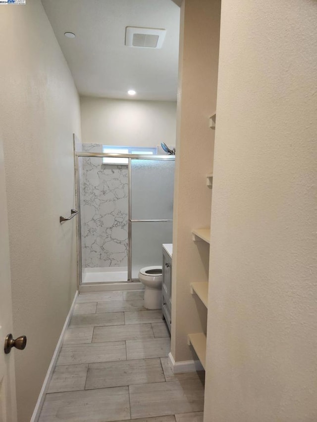 bathroom featuring walk in shower, vanity, and toilet