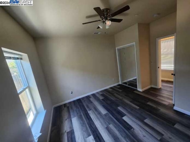 unfurnished bedroom with a closet, ceiling fan, and dark wood-type flooring