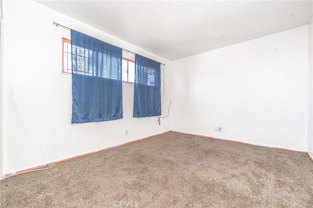 empty room featuring a textured ceiling and carpet flooring