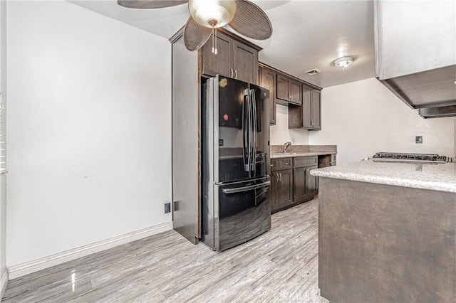11 Hickock Ln, Carson, CA 90745 - kitchen with freestanding refrigerator, dark brown cabinets, light wood-style floors, ceiling fan, and a sink
