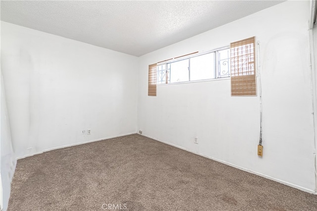 empty room with a textured ceiling and carpet flooring