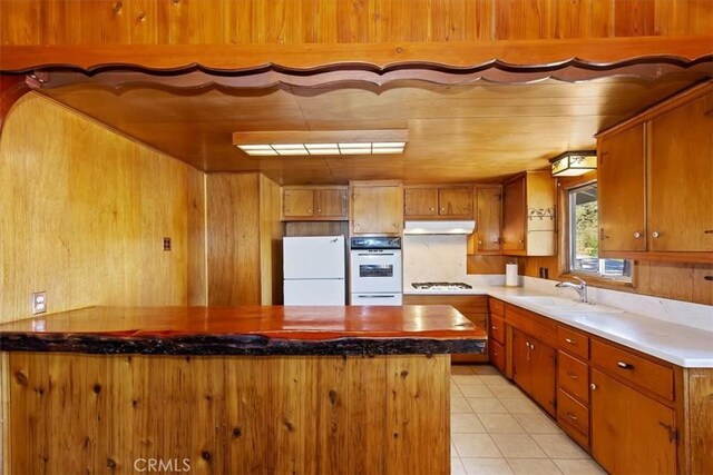 kitchen with light tile patterned flooring, sink, and white appliances