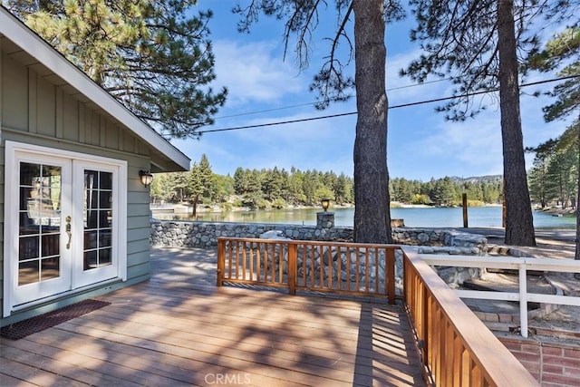 wooden deck with a water view and french doors