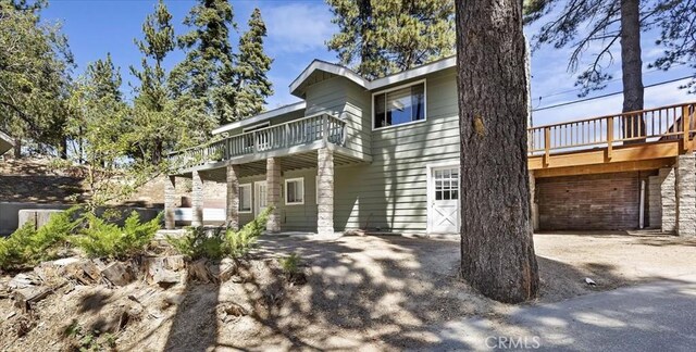 rear view of property with a deck and a garage