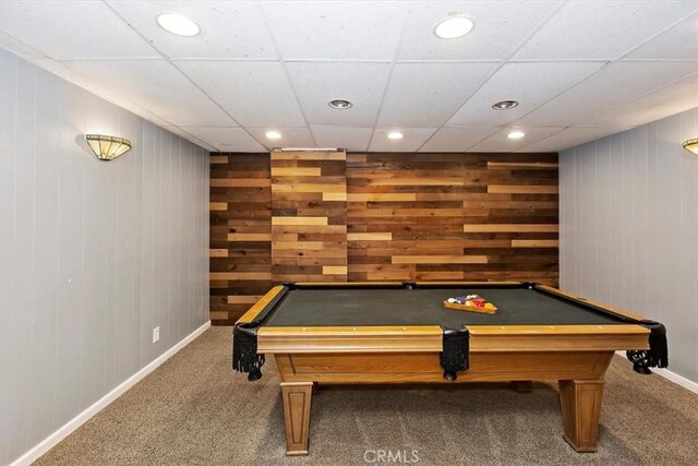 game room featuring wood walls, carpet flooring, and a paneled ceiling