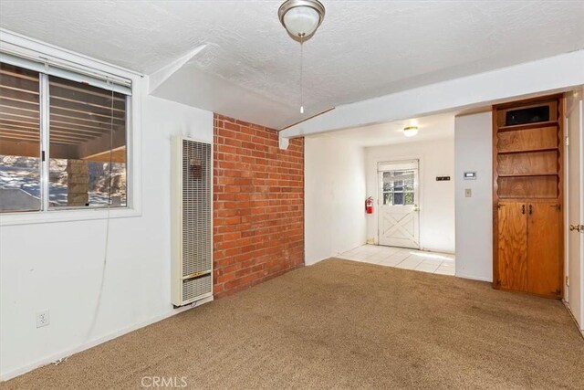 carpeted empty room with a textured ceiling