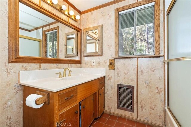 bathroom with tile patterned flooring, combined bath / shower with glass door, vanity, and crown molding