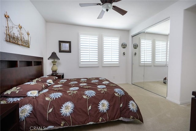 bedroom featuring ceiling fan, light colored carpet, a closet, and multiple windows