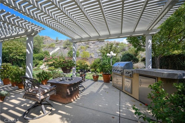 view of patio with area for grilling and a pergola