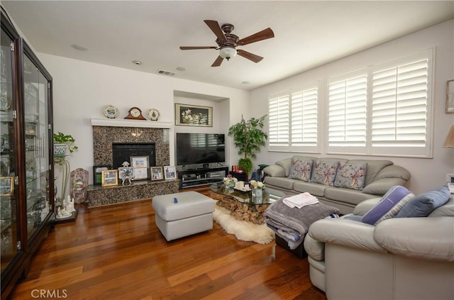 living room with dark hardwood / wood-style flooring, a fireplace, and ceiling fan