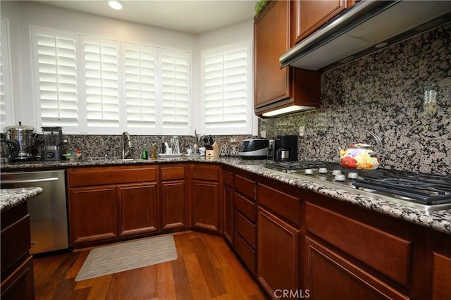 kitchen featuring range hood, decorative backsplash, dark hardwood / wood-style flooring, appliances with stainless steel finishes, and sink